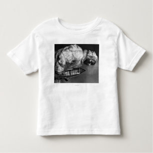 Kayaker wearing water-proof jacket with toy boat toddler t-shirt