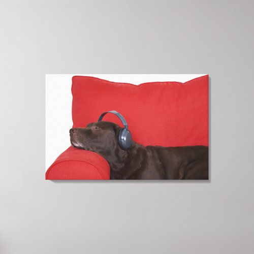 Labrador wearing headphones lying on sofa canvas print