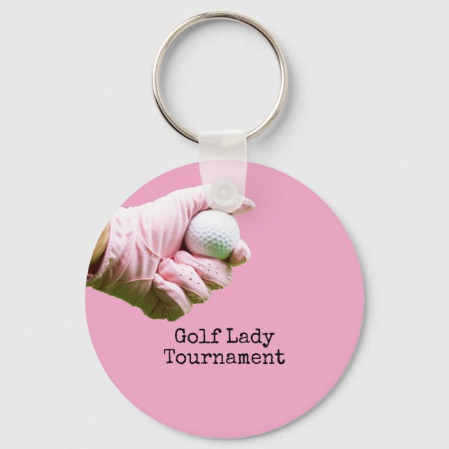 Lady golfer is holding golf ball on pinkbackground keychain (Front)