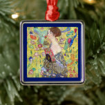 Lady with Fan by Gustav Klimt, Vintage Japonism Metal Ornament<br><div class="desc">Lady with Fan (1918) by Gustav Klimt is a vintage Victorian Era Symbolism fine art portrait painting. A beautiful brunette woman holding an oriental fan. The golden floral Japanese themed background is full of blooming exotic flowers, peacocks and other birds with outstretched wings. About the artist: Gustav Klimt (1862-1918) was...</div>