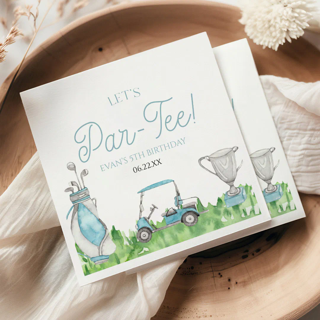A bamboo bowl with a white shawl folded in the middle. The napkin is placed at an angle on top of the shawl. There are blue fonts and cute drawings of golf clubs, a golf cart and a cup over some green grass.