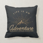 Life is an Adventure Mountain with Sunrays Throw Pillow<br><div class="desc">A pillow with a gold colored illustration on a black-gray background. Designed with an illustration of a mountain with the suns rays shining outward from behind. Typography says: Life is an Adventure explore dream discover.</div>