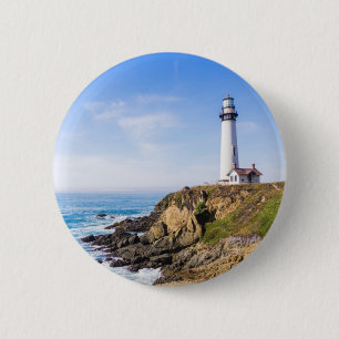 Lighthouse on hill blue sky white house ocean button