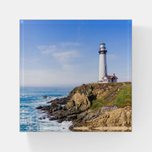 Lighthouse on hill blue sky white house ocean paperweight