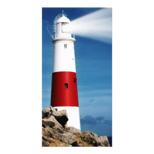 Lighthouse on rocks with light beams card