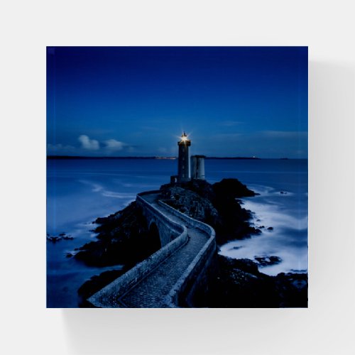 Lighthouse on wall in ocean at night paperweight