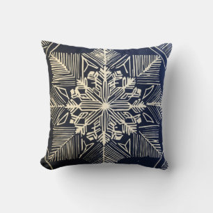 linocut design of a snowflake throw pillow