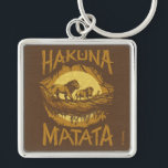 Lion King | "Hakuna Matata" Woodcut Design Keychain<br><div class="desc">This woodcut stylized design features the iconic scene with Simba,  Pumbaa,  and Timon crossing a log in the jungle with the words "Hakuna Matata" featured boldly around the graphic.</div>