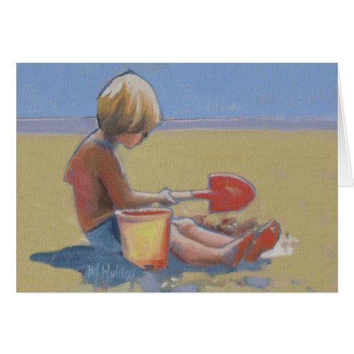 Little boy playing in the sand with a shovel