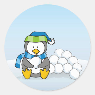 Little penguin sitting with snowballs classic round sticker