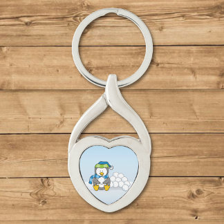 Little penguin sitting with snowballs keychain