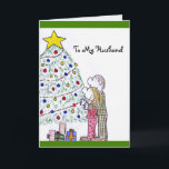 Lizzy's People Merry Christmas To My Husband Card<br><div class="desc">Message Front: "To My Husband" Message Inside: "Having you in my life makes my Christmas PERFECT! Merry Christmas!" This Christmas card features an original drawing by myself, Elizabeth Avalos, of a young husband and wife dressed in their pajamas and slippers. They are standing in front of a green bushy Christmas...</div>