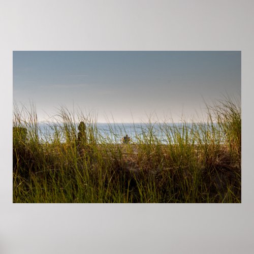 Lone person sitting on the beach poster