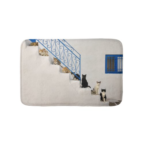 Lot of cats on a white stairway in a Greek village Bath Mat