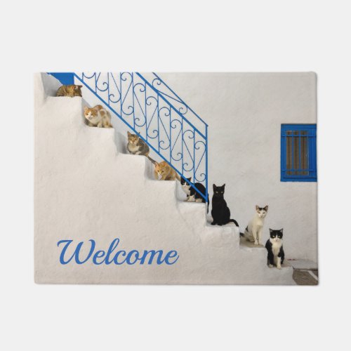 Lot of cats on a white stairway in a Greek village Doormat