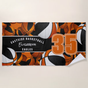 Lots of basketballs with orange black team colors beach towel