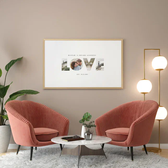 A photo print is place on a cream wall overlooking 2 red-brown chairs, with a plant to the left and a lamp to the right. 