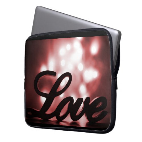 Love sign with red sparkle lights behind laptop sleeve