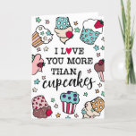 Love You More Than Cupcakes Valentine's Day Holiday Card<br><div class="desc">Sweet Valentine's Day card saying I Love You More Than Cupcakes with a heart replacing the O in love. The text is surrounded by lots of hand-drawn cupcakes in different flavors and with different toppings like frosting,  sprinkles,  and berries.</div>