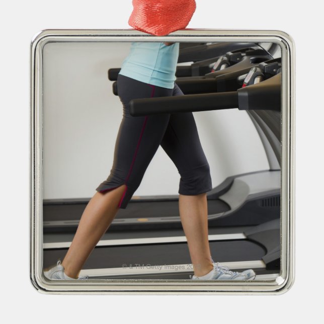 Low section of woman walking on treadmill metal ornament (Front)