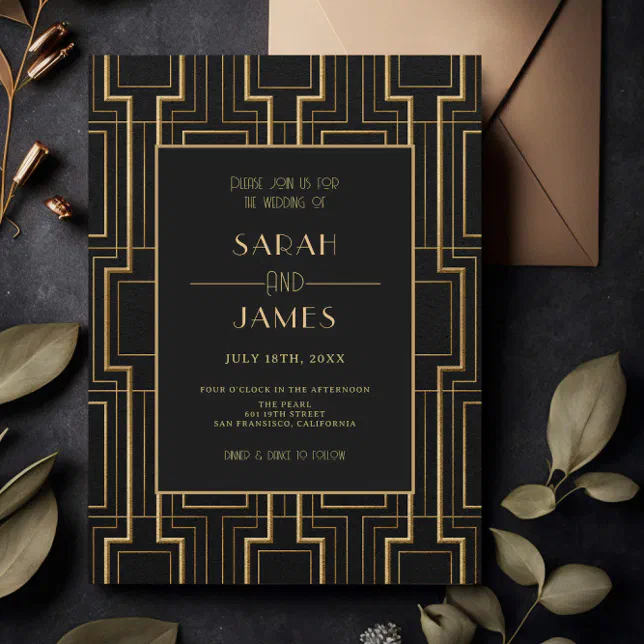 A wedding invitation with an Art Deco theme, inspired by The Great Gatsby book, sitting on a stone table with a gold envelope and greenery.