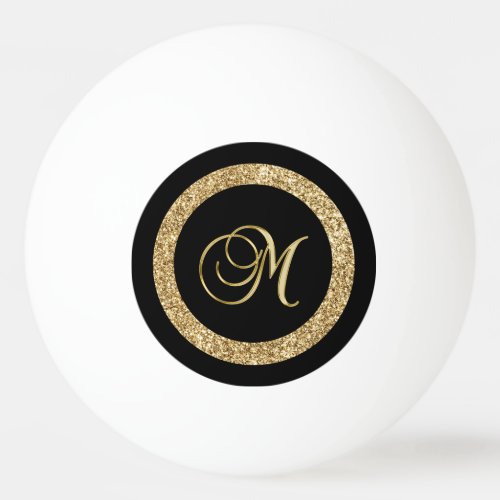 M gold monogram on black ping pong ball