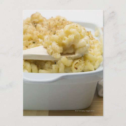 Macaroni cheese in baking dish with wooden postcard