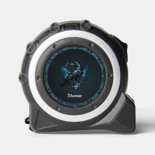 Majestic black raven sitting on an ornate tape measure