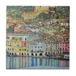 Malcesine on Lake Garda By Gustav Klimt Tile<br><div class="desc">Malcesine on Lake Garda (1913) by Gustav Klimt is a vintage Victorian Era Art Nouveau fine art symbolism painting. A beautiful view of the Italian city of Malcesine with buildings and houses on the edge of the harbor. The homes and boats cast a reflection in the calm water. You can...</div>