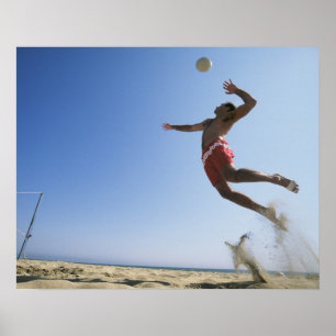 Male beach volleyball player jumping up to spike poster