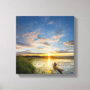 Male kayaker paddling sea kayak on still water canvas print