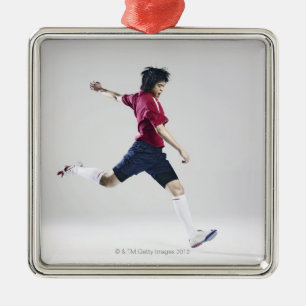 Male soccer player preparing to kick ball metal ornament