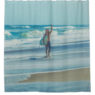 Man carrying surfboard at beach shower curtain