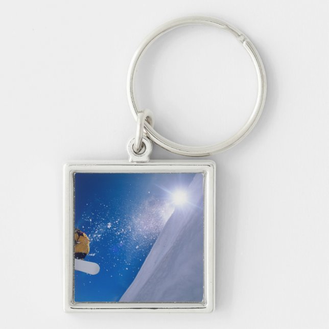 Man flying through the air on a snowboard with keychain (Front)