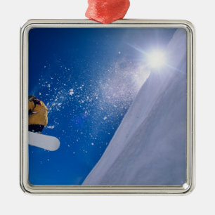 Man flying through the air on a snowboard with metal ornament