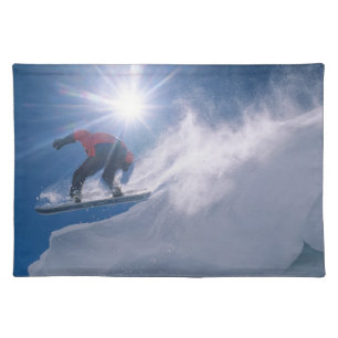 Man jumping off a large cornince on a snowboard placemat