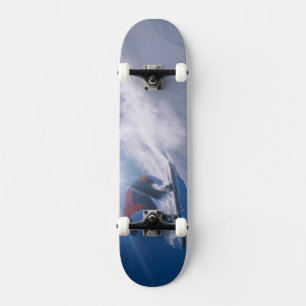 Man jumping off a large cornince on a snowboard skateboard deck