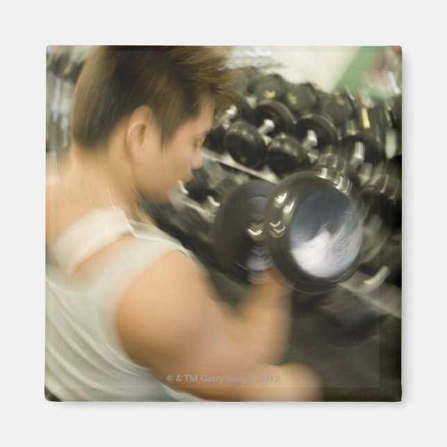 Man lifting dumbbell in gym, high angle view, magnet (Front)