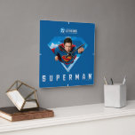 Man of Steel in Flight Square Wall Clock<br><div class="desc">Take to the skies with the ultimate symbol of heroism! This dynamic Superman design features the legendary Kryptonian bursting through his iconic S-shield, fist forward, eyes locked on justice. Set against a vivid blue background with fluffy clouds, the artwork captures the unstoppable energy of Superman in full flight—ready to save...</div>