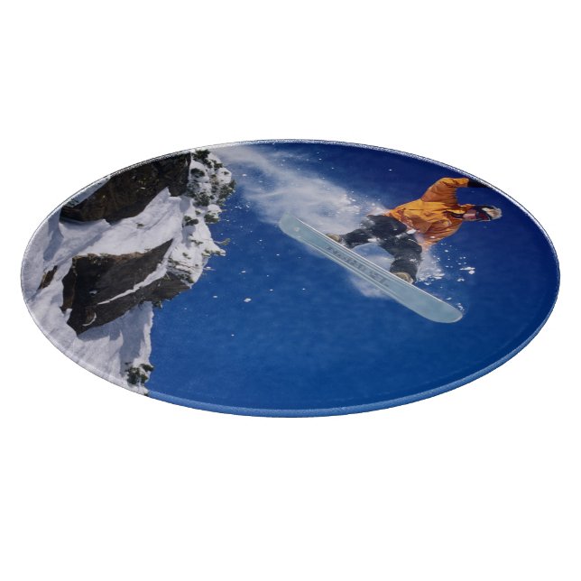 Man on a snowboard jumping off a cornice at cutting board (Corner)