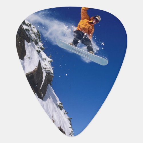 Man on a snowboard jumping off a cornice at guitar pick