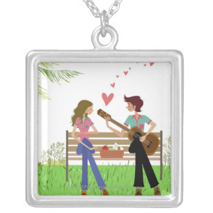 Man playing the guitar with a woman beside her silver plated necklace