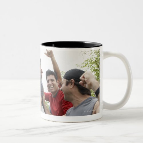 Man raising soccer ball celebrating with friends Two_Tone coffee mug