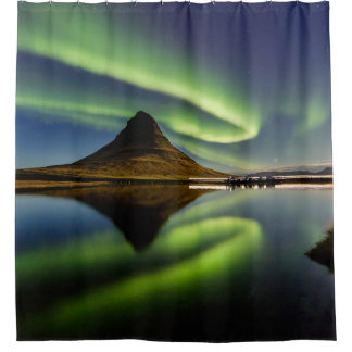 MAN STANDING BESIDE THE BODY OF WATER WITH AURORA SHOWER CURTAIN