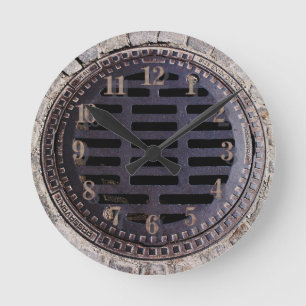 Manhole cover and cobblestone road clock