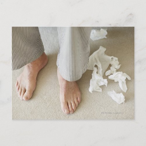 Mans feet surrounded by crumpled tissues postcard
