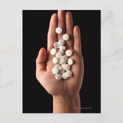Many white pills in the palm of a person postcard