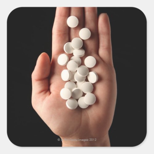Many white pills in the palm of a person square sticker