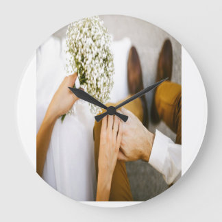 Married couple shak hands large clock