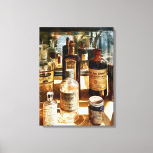 Medicine Bottles in Glass Case Canvas Print